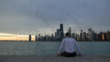 人正坐在河堤上，眺望大海和<strong>闹市</strong>.. 市中心背景是摩天大楼。